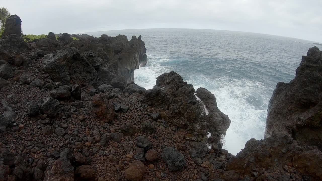 在夏威夷，缓慢的雨和海浪撞击着干涸的熔岩。海浪拍打着悬崖视频素材