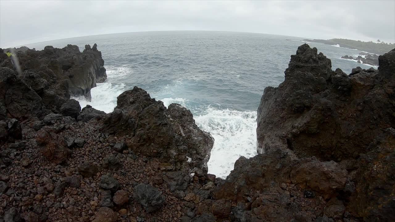 在夏威夷，缓慢的雨和海浪撞击着干涸的熔岩。海浪拍打着悬崖视频素材