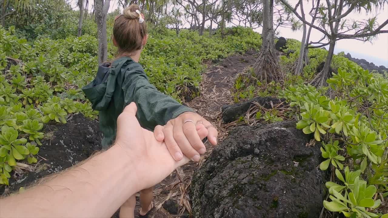 跟我来个概念，女人牵着男朋友的手去远足。夫妻手牵着手，女人带路。慢动作视频素材