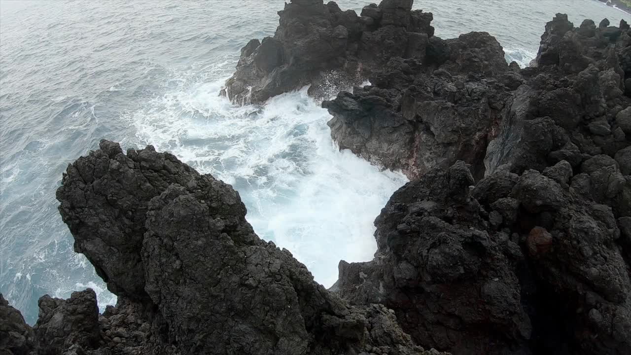 在夏威夷，缓慢的雨和海浪撞击着干涸的熔岩。海浪拍打着悬崖视频素材