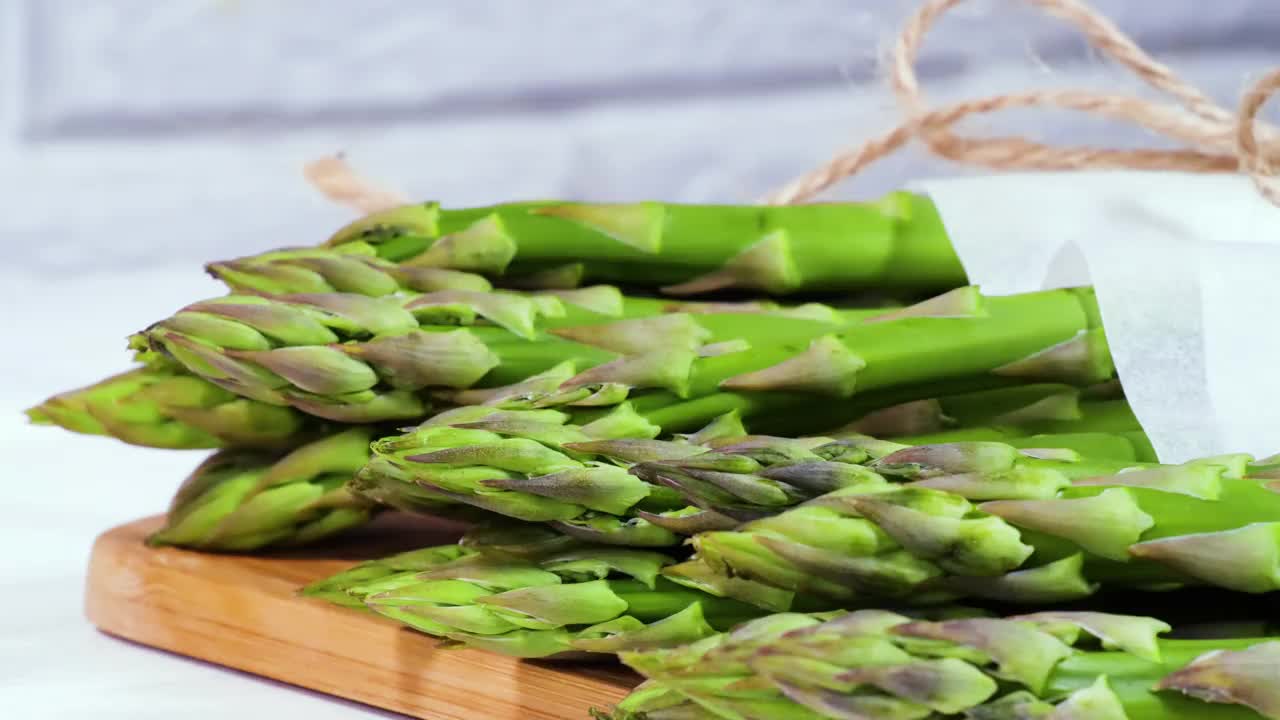 芦笋，新鲜生的绿色芦笋芽特写，健康的素食食品。生蔬菜、市场。素食的背景。慢动作4K超高清视频视频素材