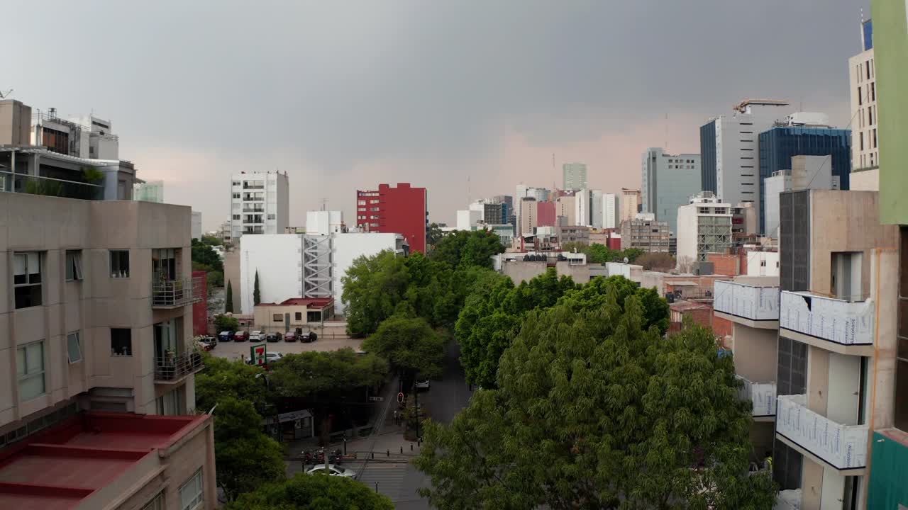 在低矮的住宅楼之上，与高耸的办公楼相邻。下雨或暴风雨前的多云天空。墨西哥城,墨西哥视频素材