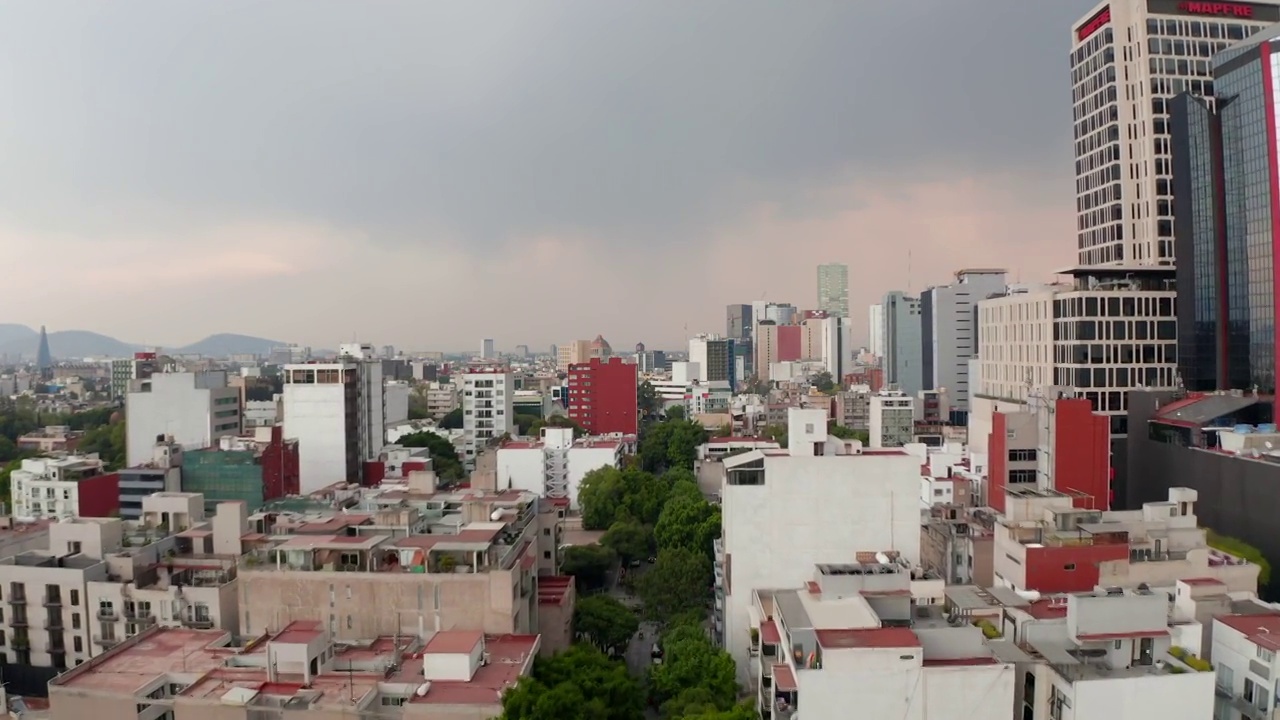 远期显示低层住宅与高层办公楼相邻。低空飞过市中心。墨西哥城,墨西哥视频素材