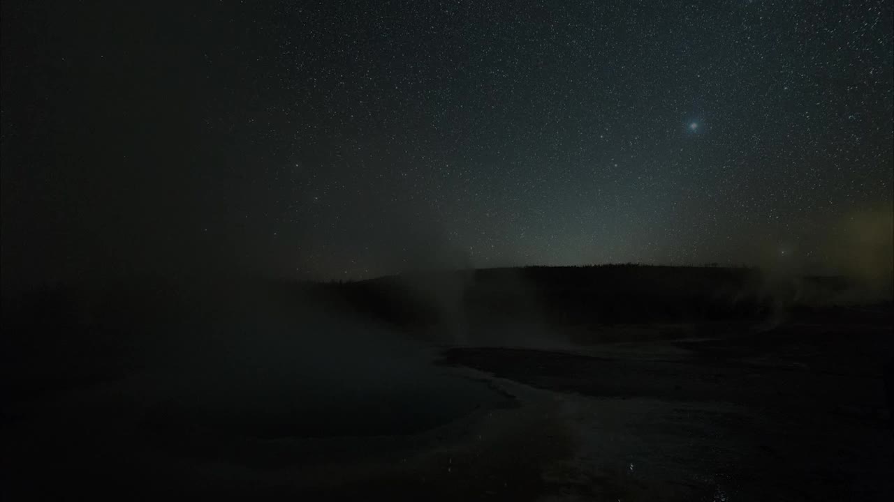 在怀俄明州的黄石国家公园里，在夜晚的温泉上空拍摄的星星视频素材