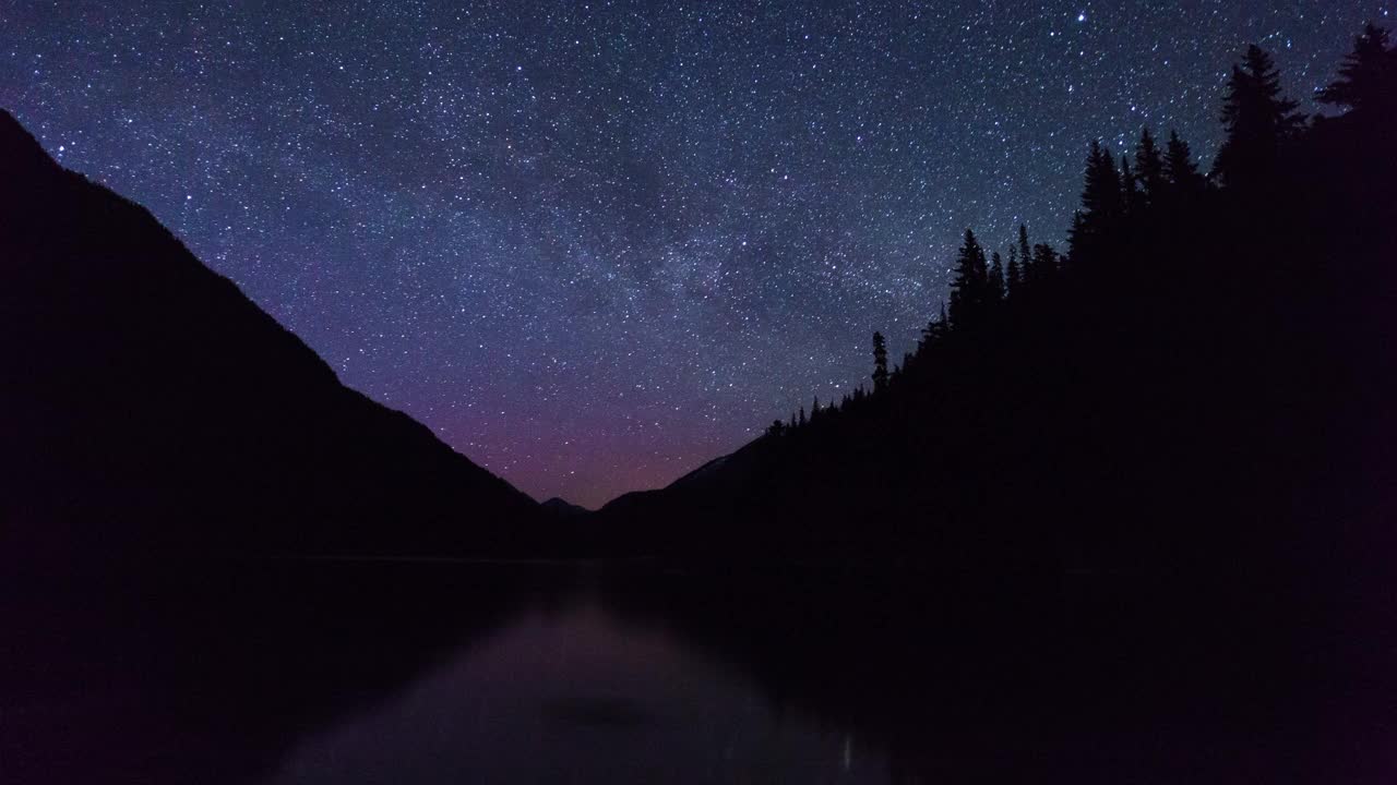 在加拿大不列颠哥伦比亚省的夜晚，星星在湖上移动的宏伟镜头视频素材