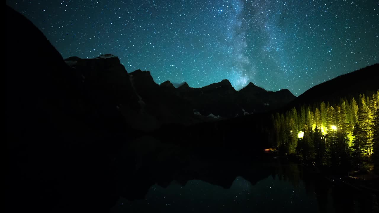 星空移过白雪皑皑的山脉与森林在夜晚的时间流逝镜头-加拿大不列颠哥伦比亚省视频素材