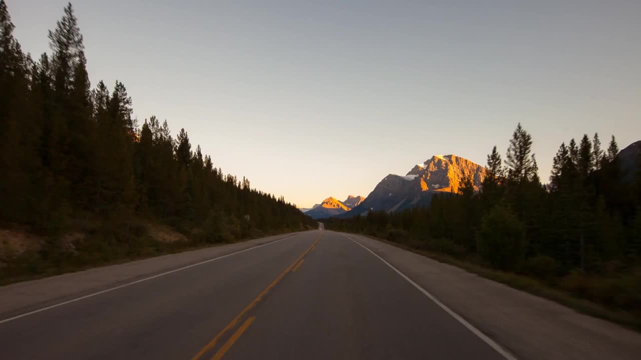 时间的推移拍摄的车辆在道路上在森林中的绿色树木在冬季-不列颠哥伦比亚省，加拿大视频素材