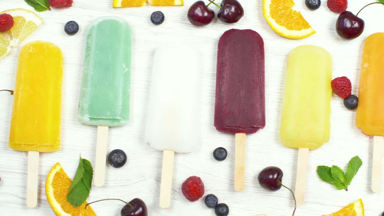 彩色冰柱与新鲜的水果在白色的背景视频素材