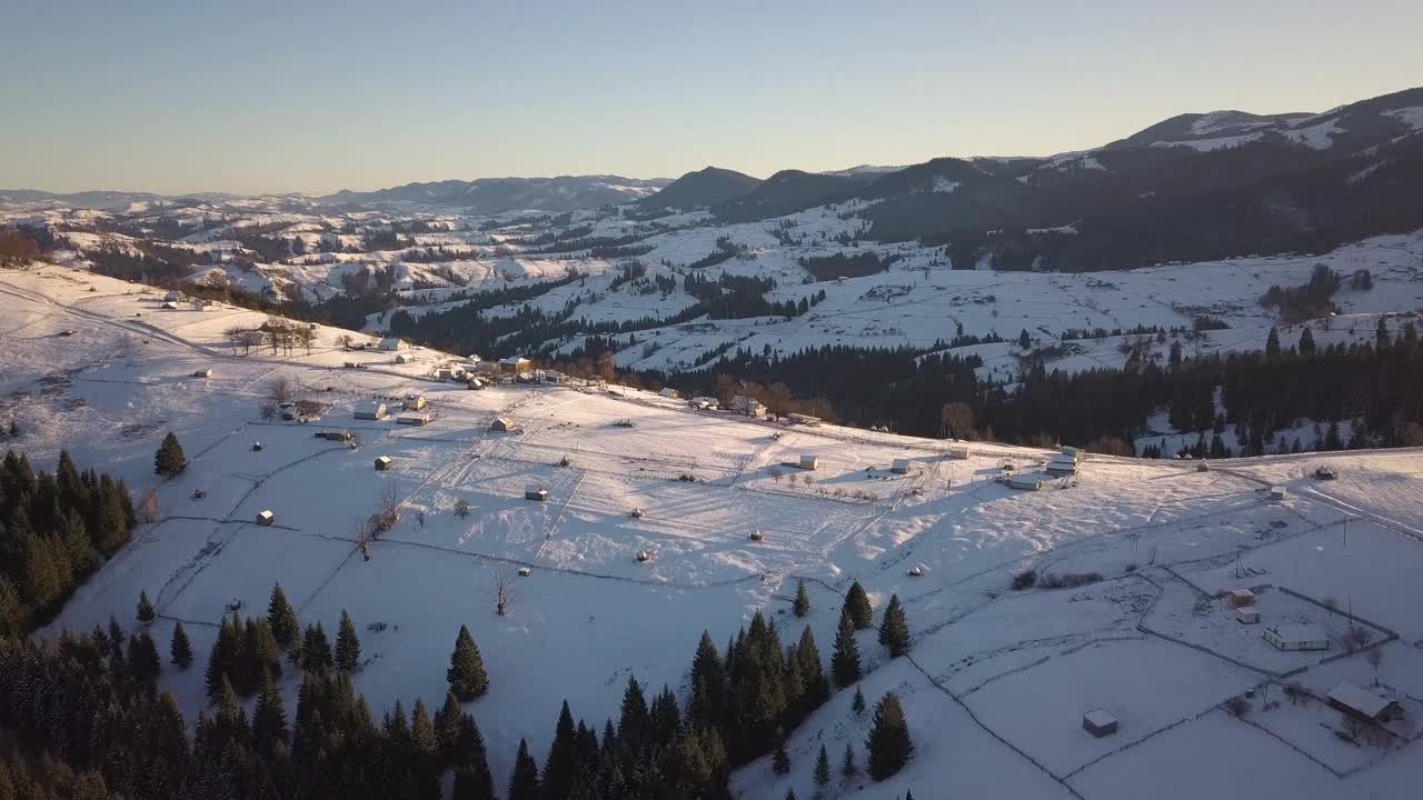 鸟瞰图上的小村庄，在冬天被雪覆盖的山丘上散落着房屋，裸露的喀尔巴阡山脉在乌克兰。视频素材