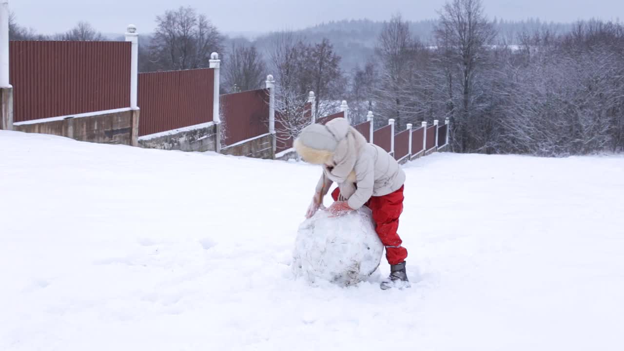 有趣的孩子在雪中玩耍。郊外的冬日周末。视频下载