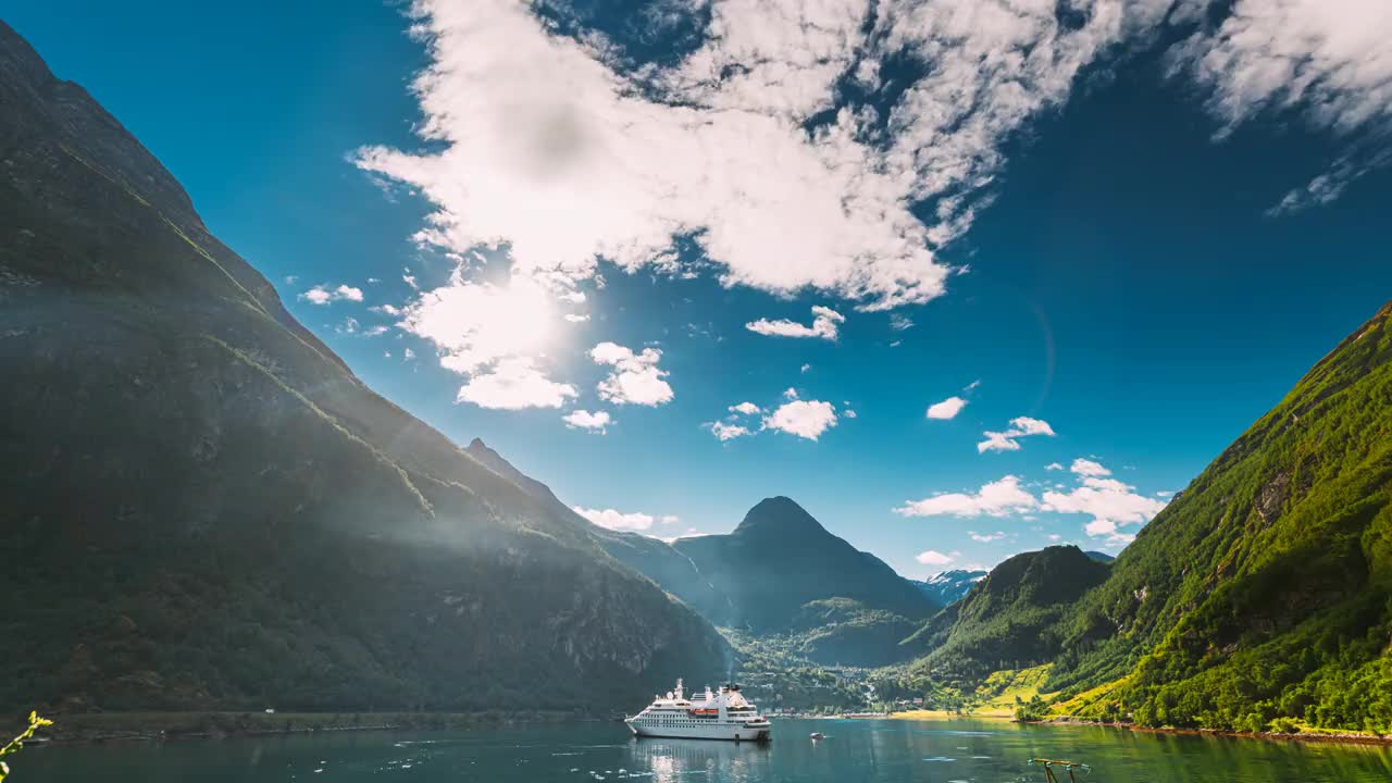 Geirangerfjord,挪威。在阳光明媚的夏天，旅游船渡船游轮班轮漂浮在Geirangerfjorden的Geiranger附近。著名的挪威地标和受欢迎的目的地。FullHD视频素材