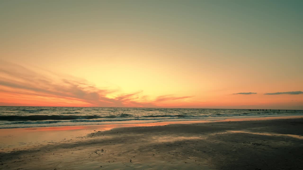 戏剧性的海上日出的超宽镜头。燃烧的天空和闪耀的金色波浪的慢镜头。视频素材