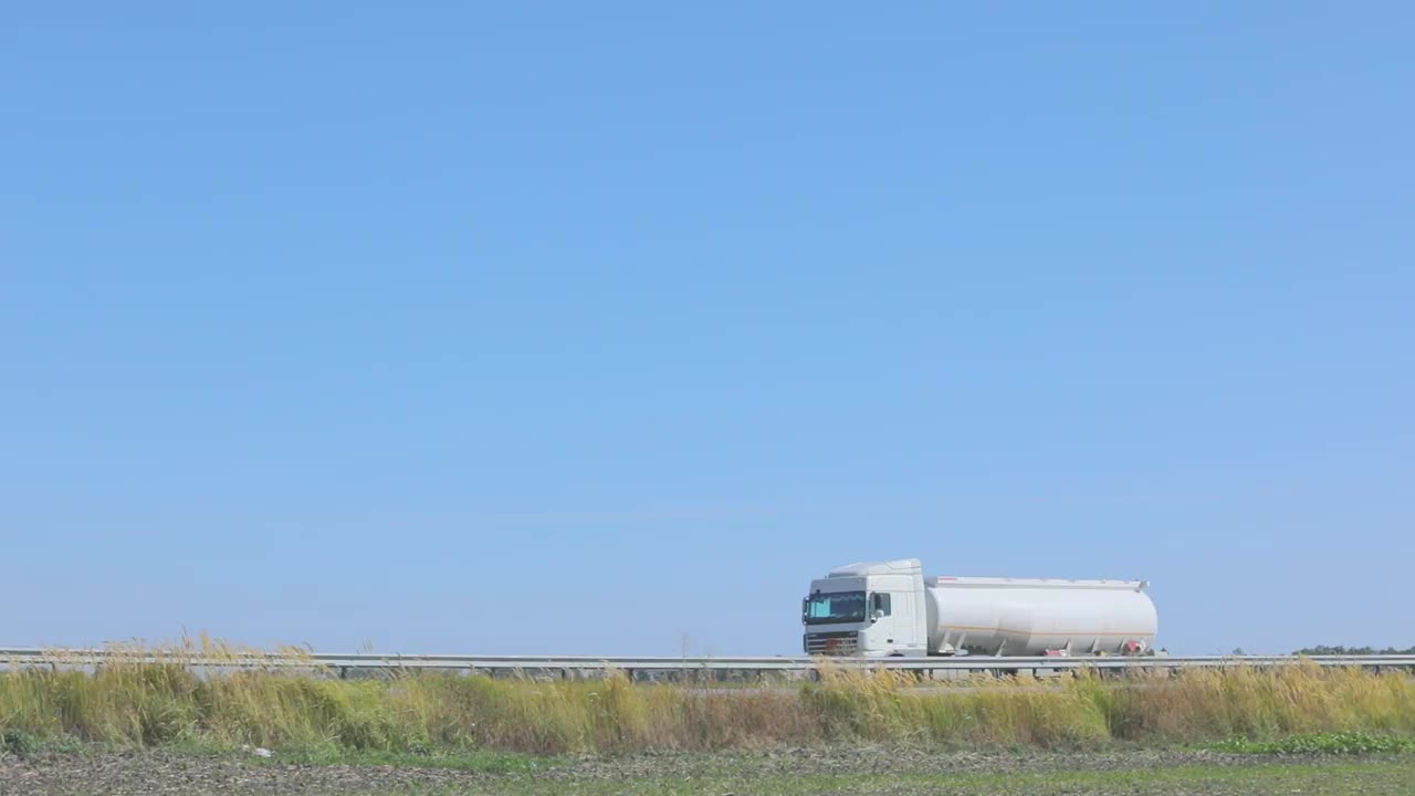 白色油罐车在高速公路上行驶。一辆油罐车在天气好的时候行驶在高速公路上视频素材