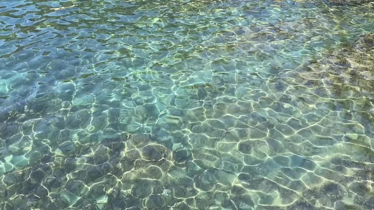 碧绿的海水，夏日美妙的海景。晶莹剔透、碧绿翠绿的海水背景。热带海浪。卵石滩。美妙的闪闪发光的水。放松，禅意，清新，夏日时光。视频素材