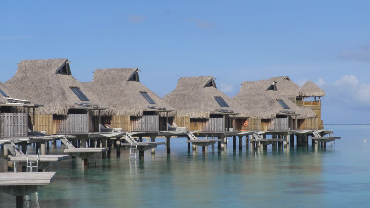 度假酒店在旅游度假天堂与水上平房在海洋泻湖与珊瑚礁海。来自波拉波拉，法属波利尼西亚，塔希提岛，南太平洋的4K视频。视频素材