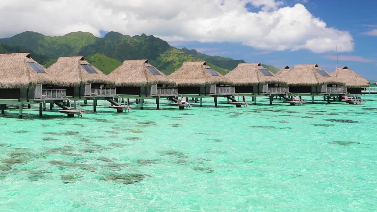 度假酒店在旅游度假天堂与水上平房在海洋泻湖与珊瑚礁海。来自波拉波拉，法属波利尼西亚，塔希提岛，南太平洋的4K视频。视频素材