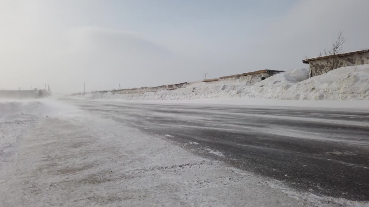 风把雪吹过马路。冬天的暴风雪。雪堆关闭视频素材