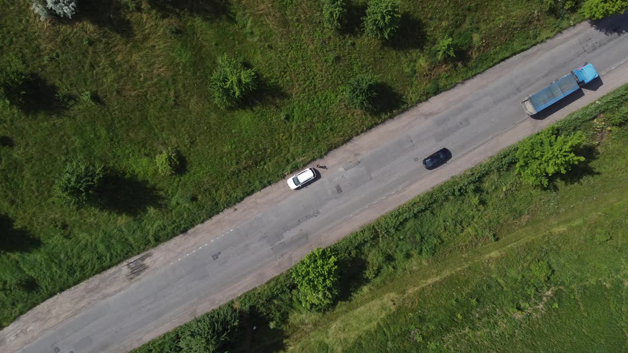 农村道路鸟瞰图。沿途的稻田。途经耕地、乡村的道路。视频素材