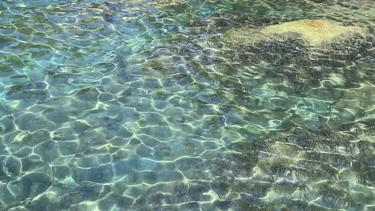 清澈碧蓝的海水，夏日美妙的海景。晶莹剔透、碧绿翠绿的海水背景。热带海浪。卵石滩。美妙的闪闪发光的水。放松，禅意，清新，夏日时光。视频素材