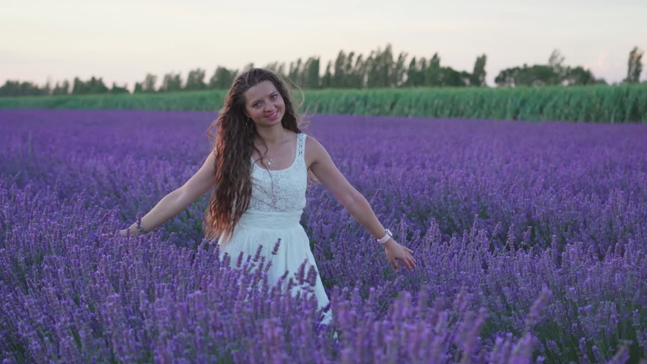 美丽快乐的女孩在盛开的薰衣草中视频素材