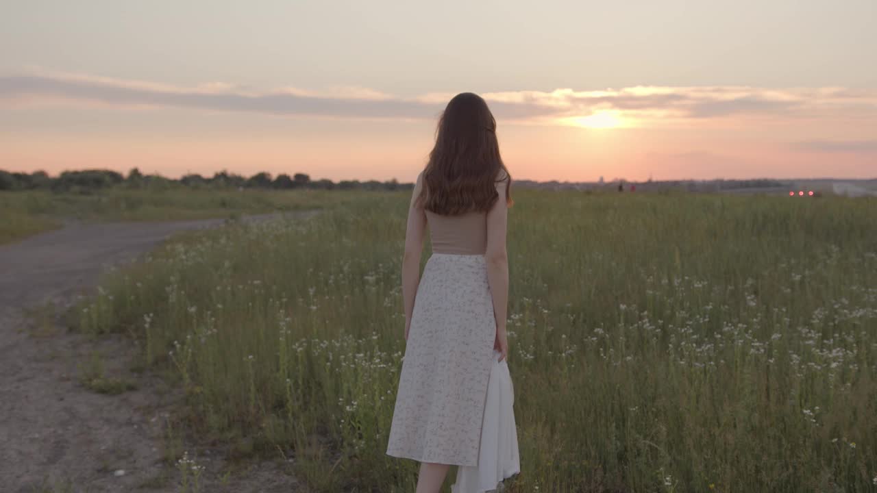 背影的女人在夏天的衣服走在农村视频素材