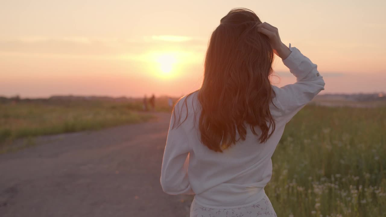 顽皮的女人穿着夏装走在田野上视频素材