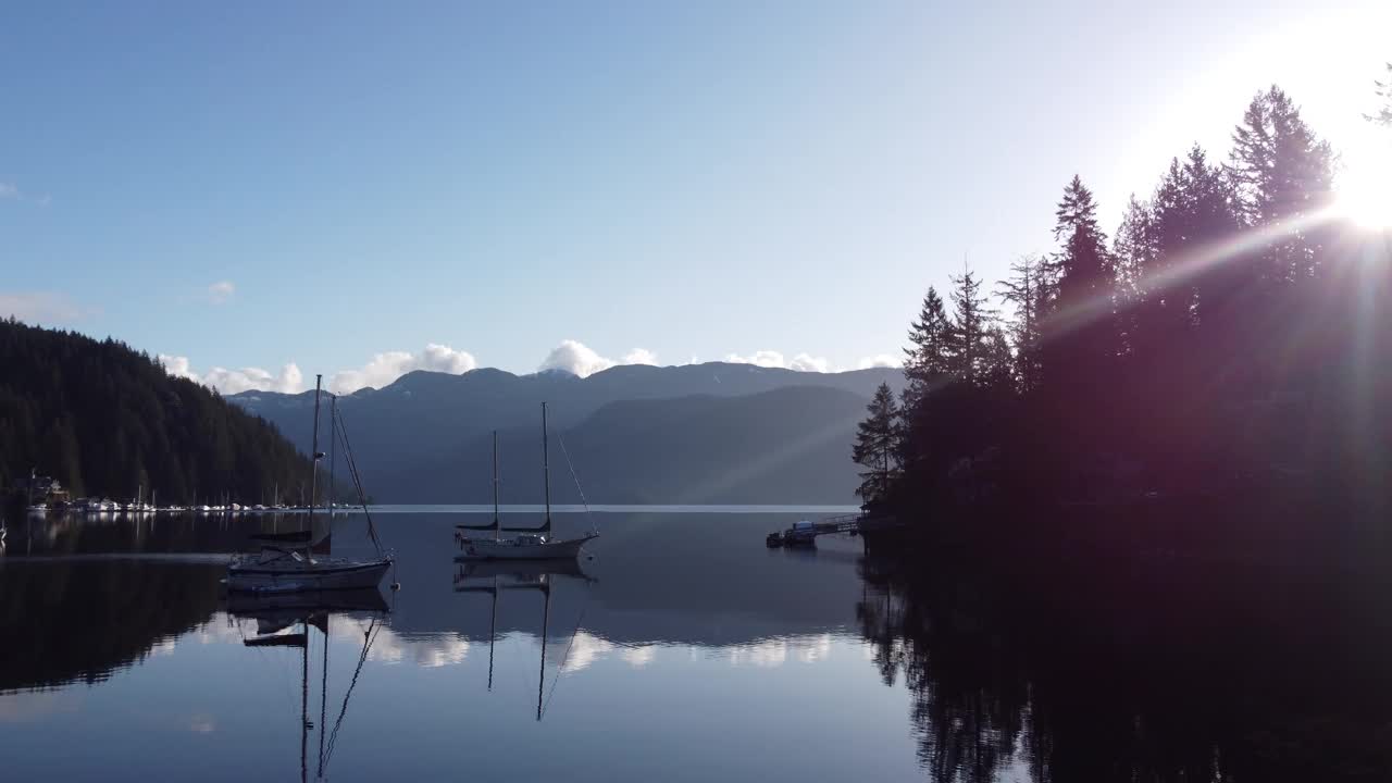 清晨的阳光在海湾与停泊的游艇和山周围的森林视频素材