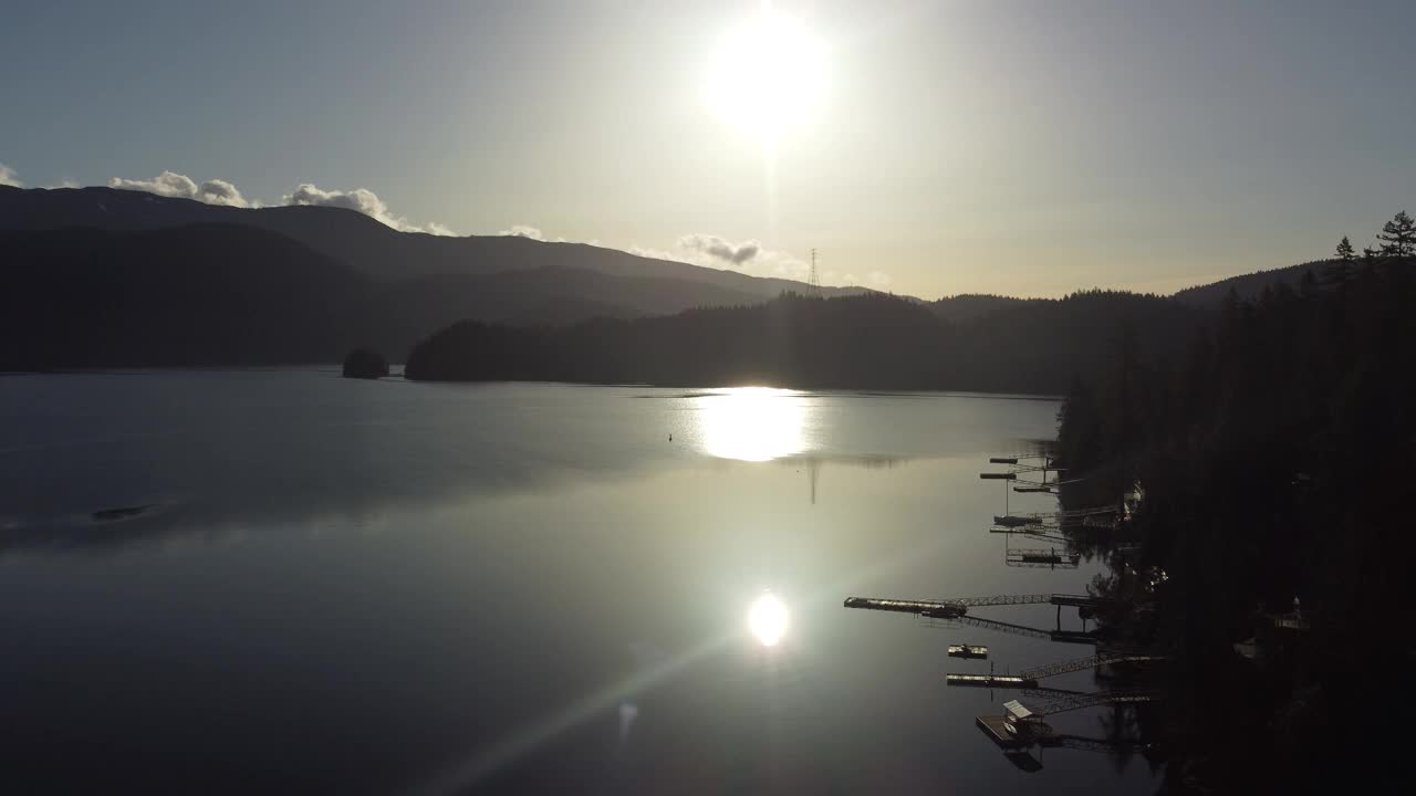 鸟瞰图镜子平静的水在海湾与明亮的太阳和山周围视频素材