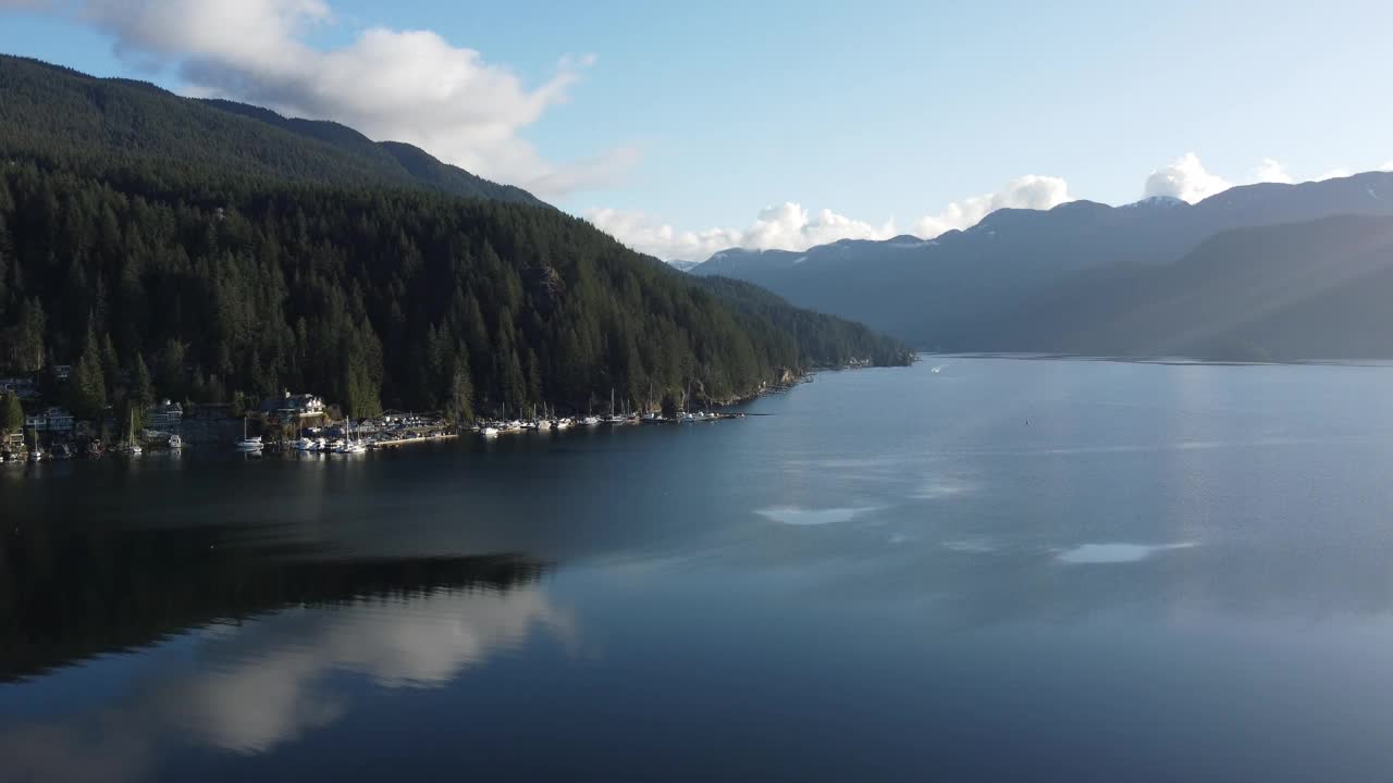 飞过平静的海湾水面，四周群山绿树成荫视频素材