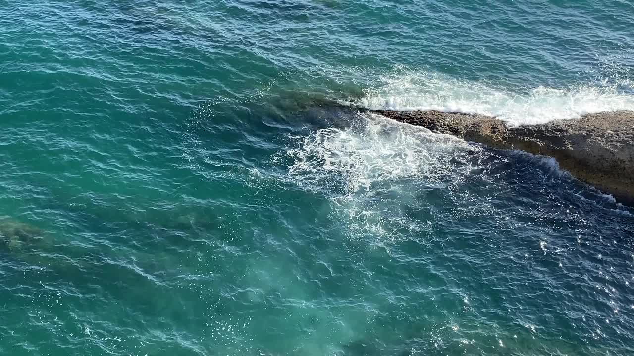 海浪拍打着海岸的岩石。蓝绿色的海水彩。美丽闪亮的地中海海岸海景。视频素材