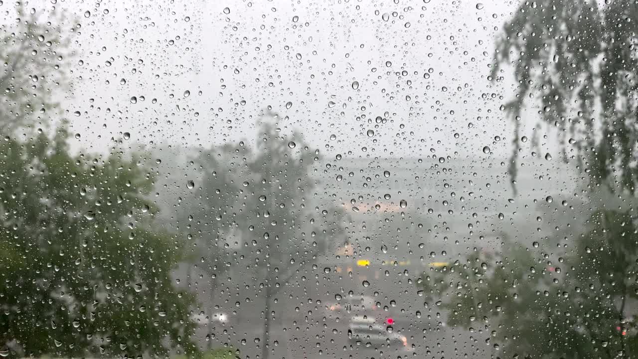 在特写镜头中，大雨中的雨滴顺着窗户流下。飓风风视频素材