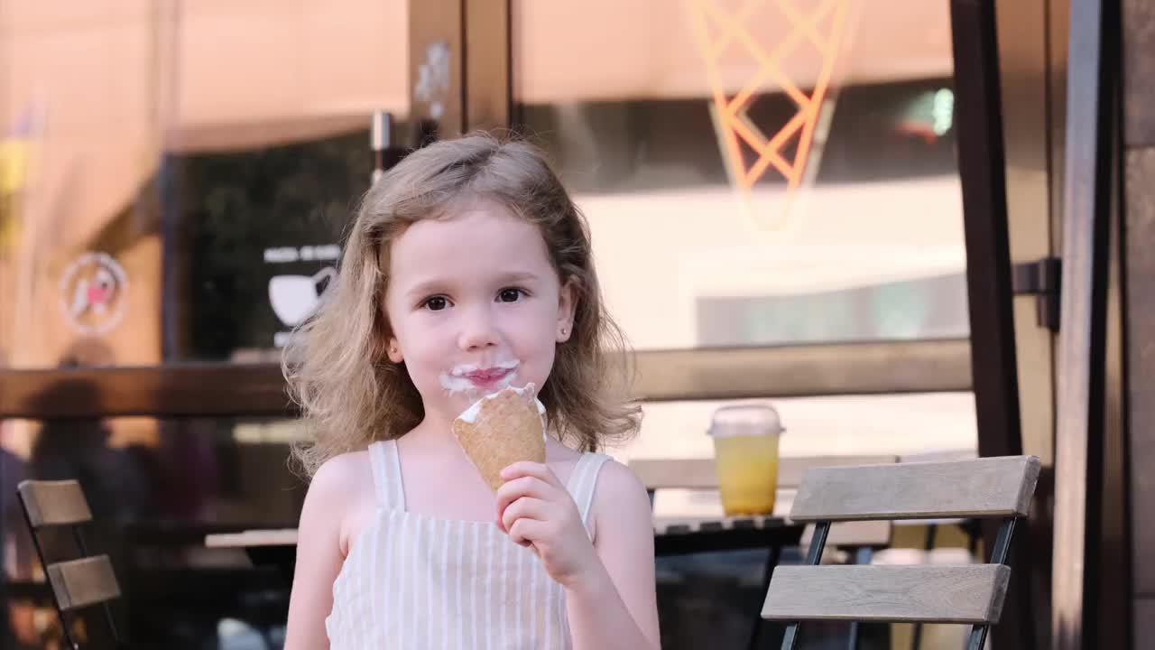 孩子们在咖啡馆附近吃冰淇淋。冰冻的夏季食物视频素材