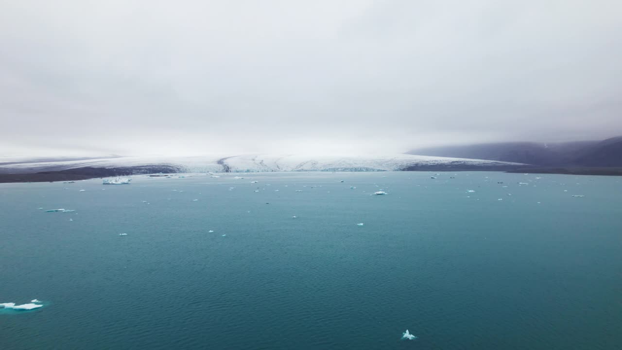 冰山散落在海洋与山脉的视野在晴朗的天空视频素材