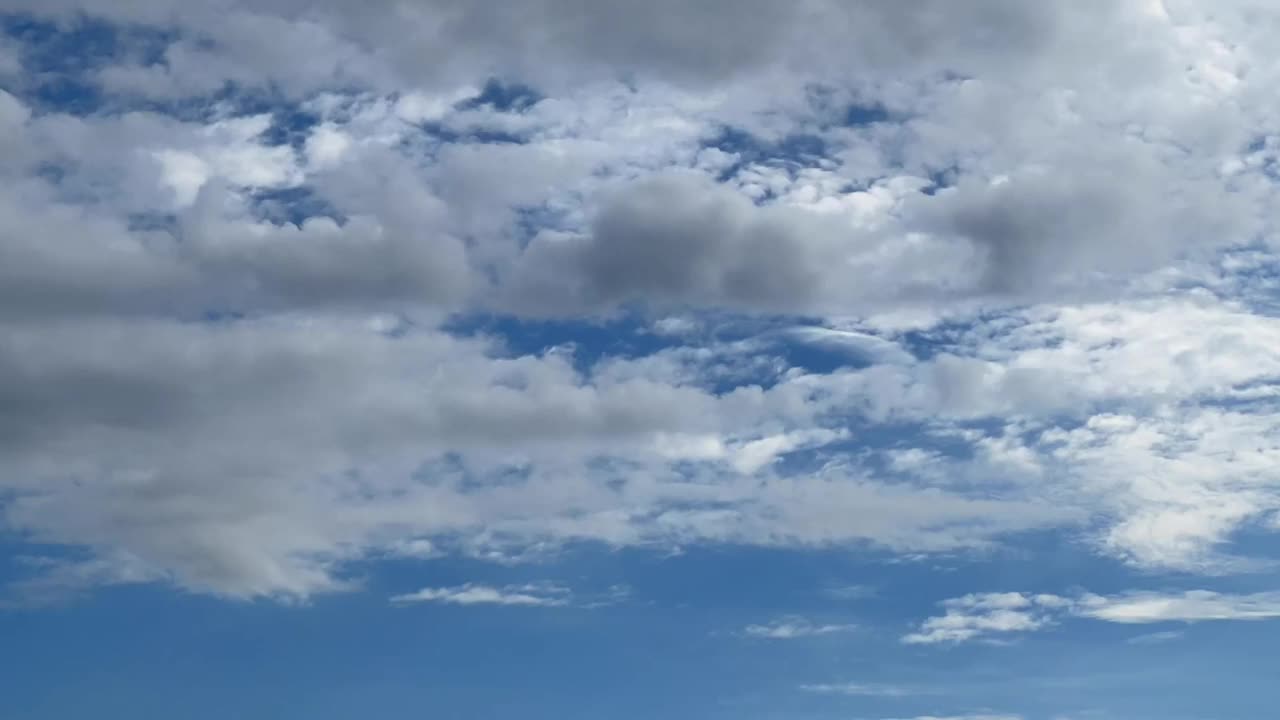 各种形状的白云和蓝天后，灰色的云消失了视频素材