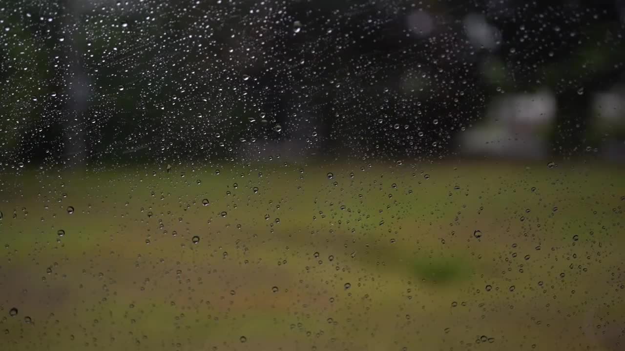 雨点落在汽车镜子上。开车时，雨点落在汽车挡风玻璃上。窗外下着大雨。多云多雨的天气。视频素材