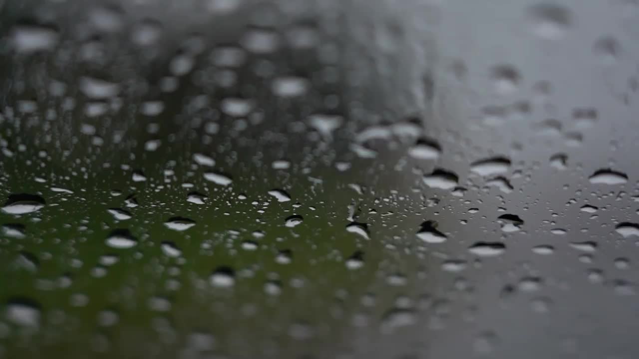 雨天落在汽车镜子上。防止汽车雨点滴落在汽车挡风玻璃上。视频素材