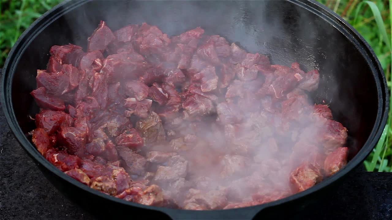 红肉在大锅里的油里汩汩地沸腾。东方菜的烹饪过程传统的亚洲菜视频下载