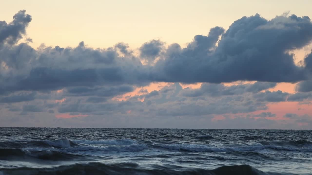 波罗的海，石头，美丽的日落与橙色粉红色的天空视频下载