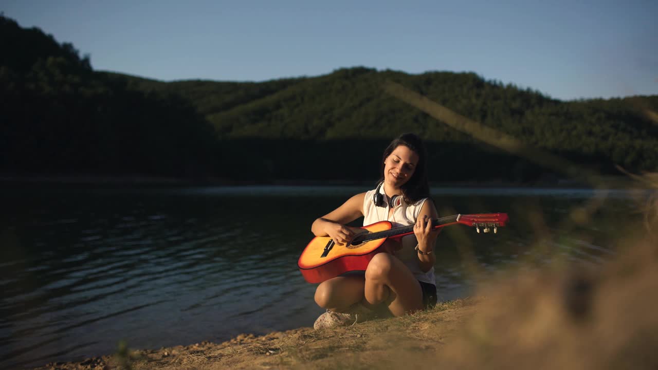 在湖边弹吉他的女人视频素材