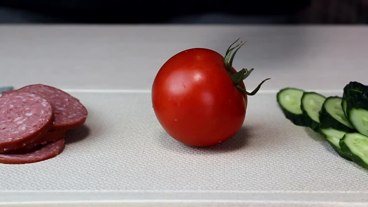 一个男人切了一个红番茄，准备做一顿美味的午餐视频下载