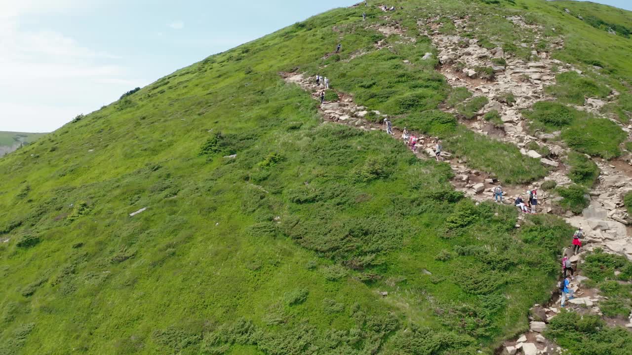 年轻游客沿着山路走到山顶的鸟瞰图。视频素材