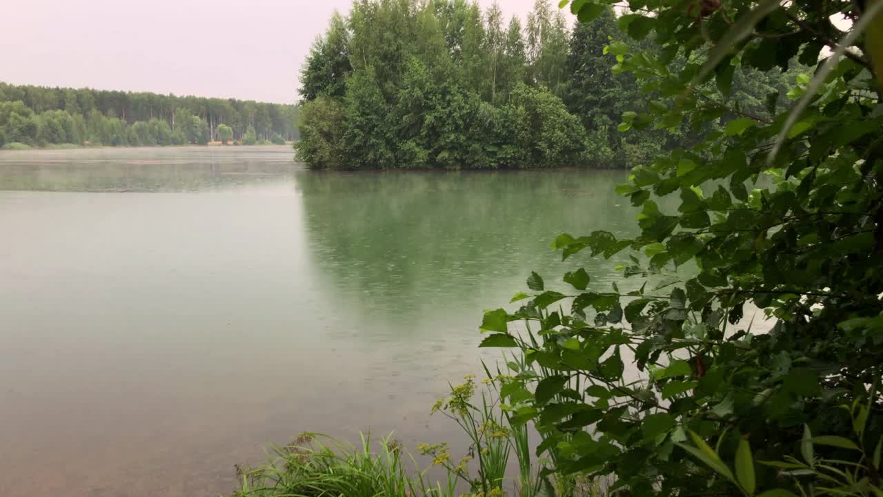 湖边的雨天。雨滴落在水面上，形成小圆圈。视频素材