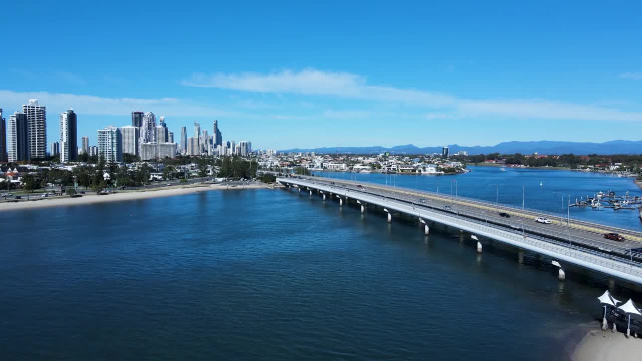 繁忙的城市道路网络和横跨一大片水域的桥梁，通向大都市的蔓延和高耸的天际线。视频素材