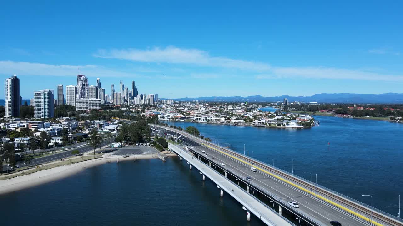 繁忙的城市道路网络和横跨一大片水域的桥梁，通向大都市的蔓延和高耸的天际线。视频素材