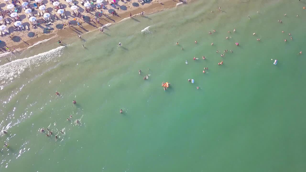 鸟瞰夏天的海滩，人们在水里视频素材