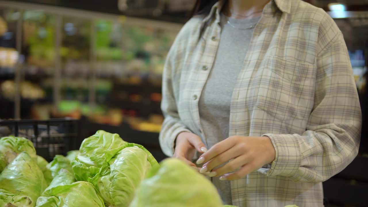 一位妇女在超市里挑选小白菜。新鲜蔬菜，健康食品视频素材