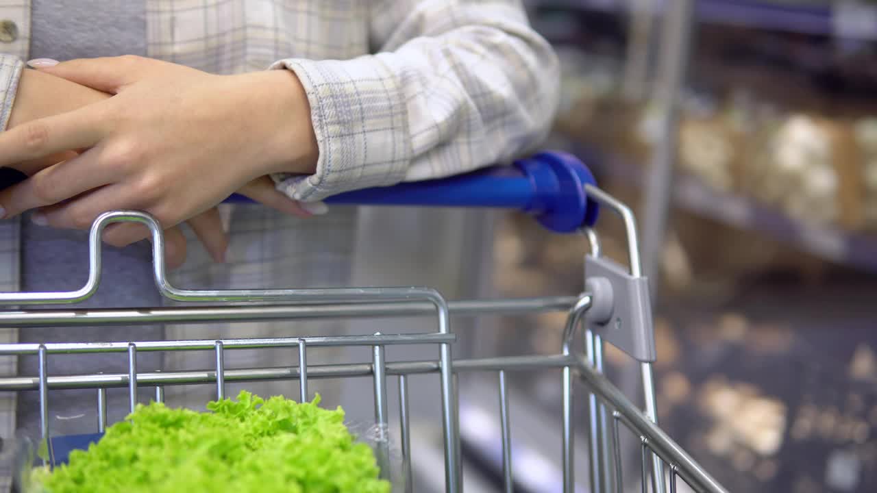 女人推着购物车，走在超市里。健康食品购物视频素材