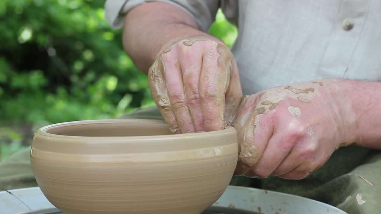 一名白人男性陶工在自动电子圆机上制作棕色陶罐视频素材