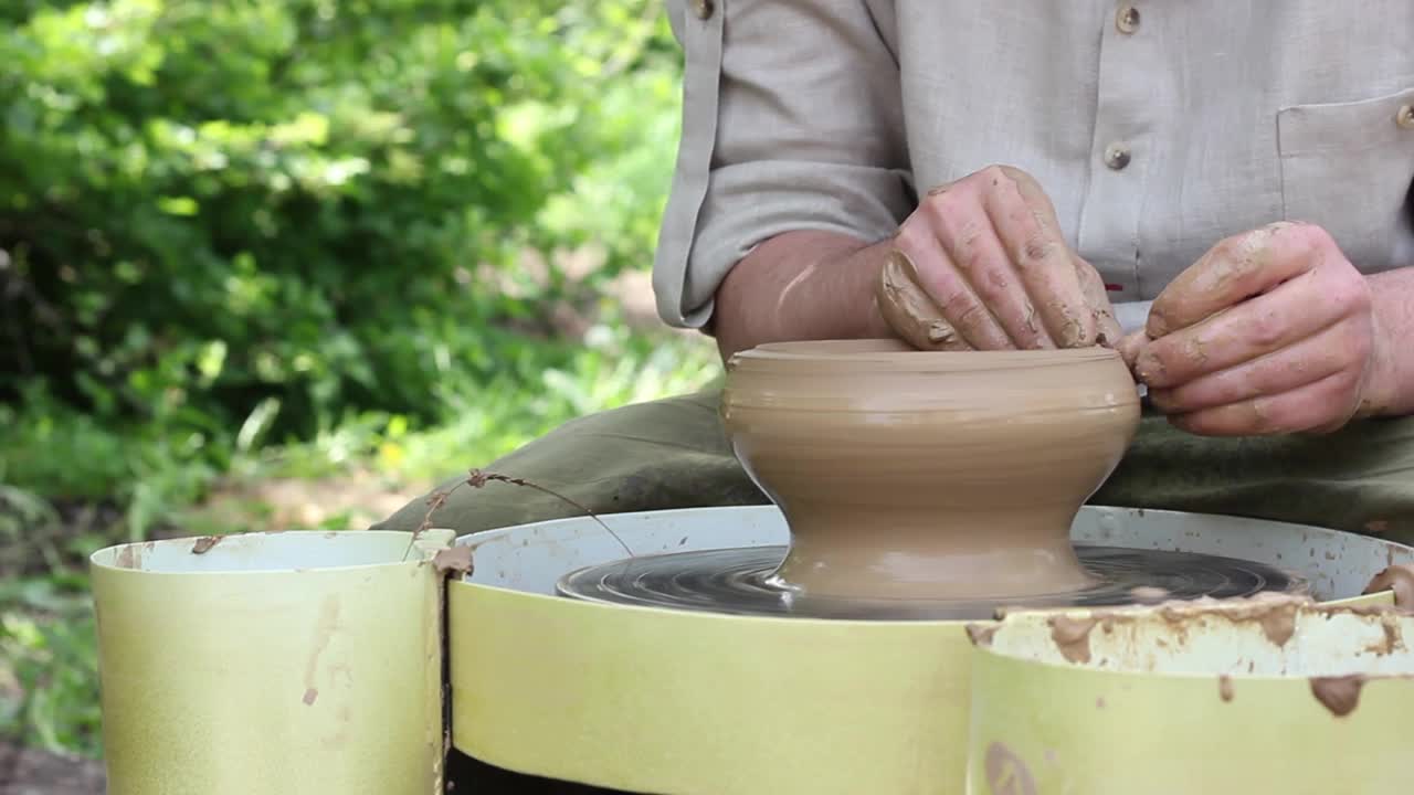 一名白人男性陶工在自动电子圆机上制作棕色陶罐视频素材