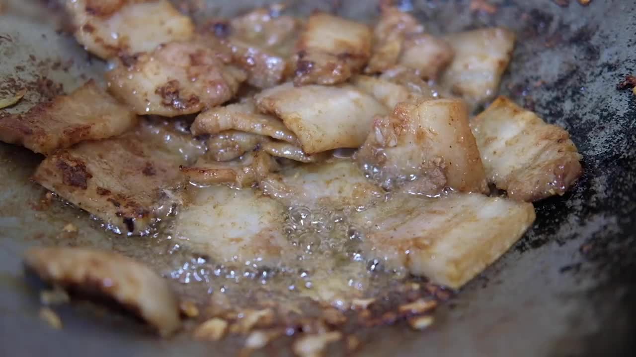 用热锅煎蒜头和辣椒炒五花肉视频素材